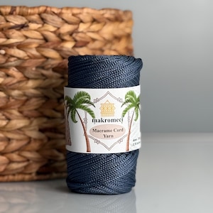 Puede incluir: Una bobina de hilo de macramé azul oscuro con una etiqueta que dice "makromeci Macrame Cord Yarn".