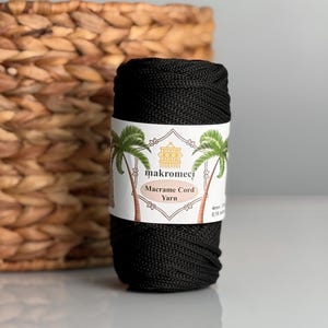 Puede incluir: Una bobina de hilo de macramé de color negro con una etiqueta blanca que dice "makromeci Macrame Cord Yarn 4mm 0.16 inch".