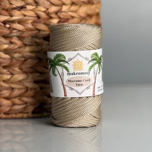 May include: A spool of beige macrame cord yarn with a label that reads "makromeci Macrame Cord Yarn".