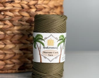 May include: A spool of olive green macrame cord yarn with a white label that reads "makromeci Macrame Cord Yarn".