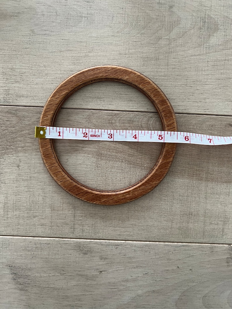 Puede incluir: Un aro de bordado de madera con un di&aacute;metro de 15,2 cm. El aro es de color marr&oacute;n y tiene un acabado de madera natural.