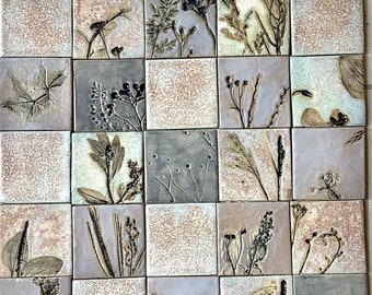 May include: A wall art piece made of 16 square tiles, each featuring a different pressed botanical design. The tiles are arranged in a grid pattern and have a light brown, gray, and purple color scheme.