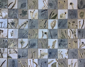May include: A wall covered in 49 small square tiles, each featuring a different pressed botanical design in shades of gray, brown, and white.