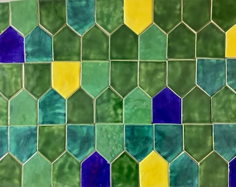 May include: A wall covered in green, yellow, and purple hexagonal tiles. The tiles are arranged in a repeating pattern.