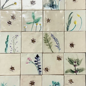 May include: A set of 16 ceramic tiles featuring various floral and bee designs. Each tile is a different colour and features a unique design. The tiles are perfect for adding a touch of nature to any space.