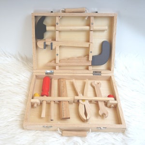 Der Koffer im Einsatz, ein Kind spielt mit den Werkzeugen, um die Nutzung des Spielzeugs zu veranschaulichen.