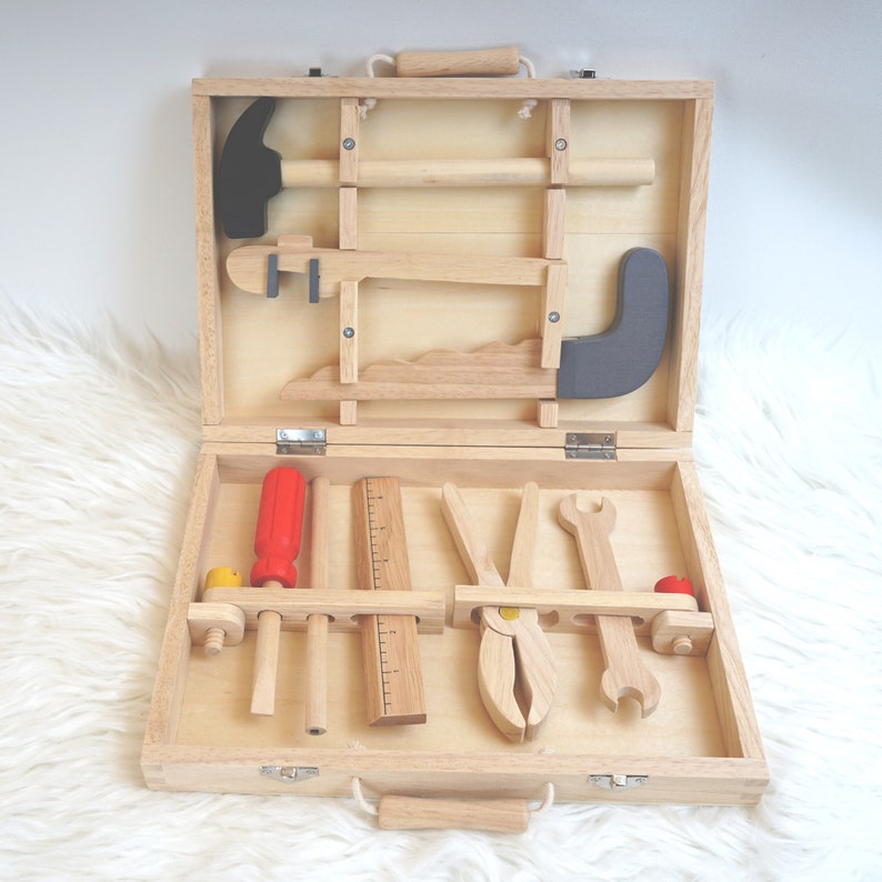 Der Koffer im Einsatz, ein Kind spielt mit den Werkzeugen, um die Nutzung des Spielzeugs zu veranschaulichen.