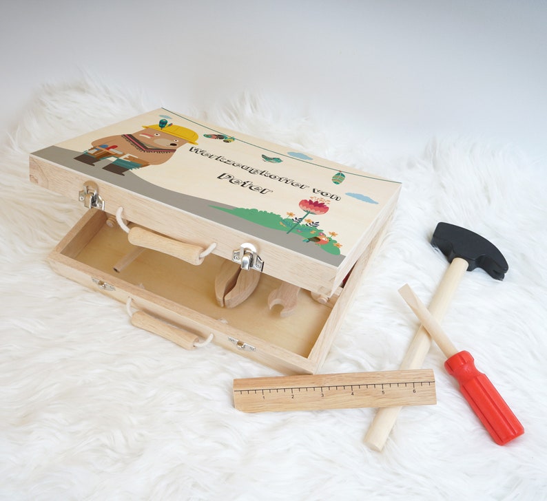 Abmessungen des Werkzeugkoffers, dargestellt mit einem Maßband zur Verdeutlichung der Größe von etwa 29 x 21 x 7 cm.