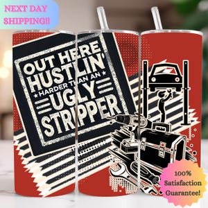 Op de afbeelding: Een rode, witte en zwarte tumbler met de tekst "Out Here Hustlin' Harder Than An Ugly Stripper" en een auto op een brug. De tumbler heeft een rietje en een 100% tevredenheidsgarantie.