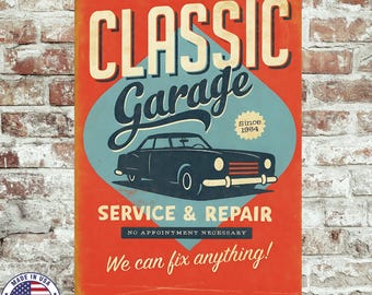 May include: A vintage-style metal sign with an orange background and the words "CLASSIC Garage" in cream-colored lettering. A blue oval features a classic car illustration and the text "SERVICE & REPAIR". The sign reads "We can fix anything!"