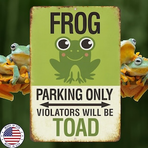 May include: A distressed metal sign with a green background features a cartoon frog and the words "FROG PARKING ONLY VIOLATORS WILL BE TOAD." The sign has a vintage look, with a faded appearance. The sign is surrounded by real frogs.