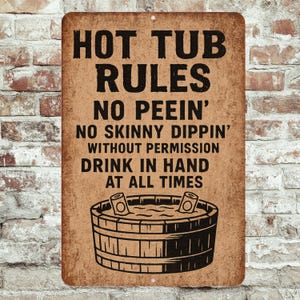 May include: A rectangular metal sign with the text "HOT TUB RULES" in bold black letters. The sign also includes the phrases "NO PEEIN'", "NO SKINNY DIPPIN'", "DRINK IN HAND AT ALL TIMES", and an illustration of a hot tub.