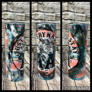 May include: A stainless steel tumbler with a colorful abstract design. The tumbler has a black and white graphic that says "Tryna stay out of AA".