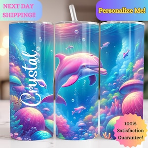 May include: A personalized tumbler with a pink dolphin swimming in a colorful underwater scene. The tumbler has the name "Crystal" written on it.