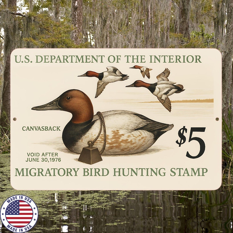 Może przedstawiać: Zabytkowy znak Departamentu Spraw Wewnętrznych Stan&oacute;w Zjednoczonych z ilustracją kaczki Canvasback. Znak zawiera tekst "Migratory Bird Hunting Stamp" i cenę 5 $. Znak jest kremowy z naklejką "Made in USA".
