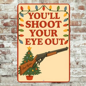 May include: A rectangular metal sign with a cream background and a red border. The sign features the text "YOU'LL SHOOT YOUR EYE OUT" in red, with a Christmas tree and a rifle illustration. A string of colourful Christmas lights decorates the top.
