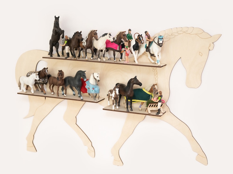 May include: Wooden horse-shaped shelf with two shelves, displaying a collection of miniature horse figurines and riders. The figurines are in various poses and colors, including brown, black, white, and gray.
