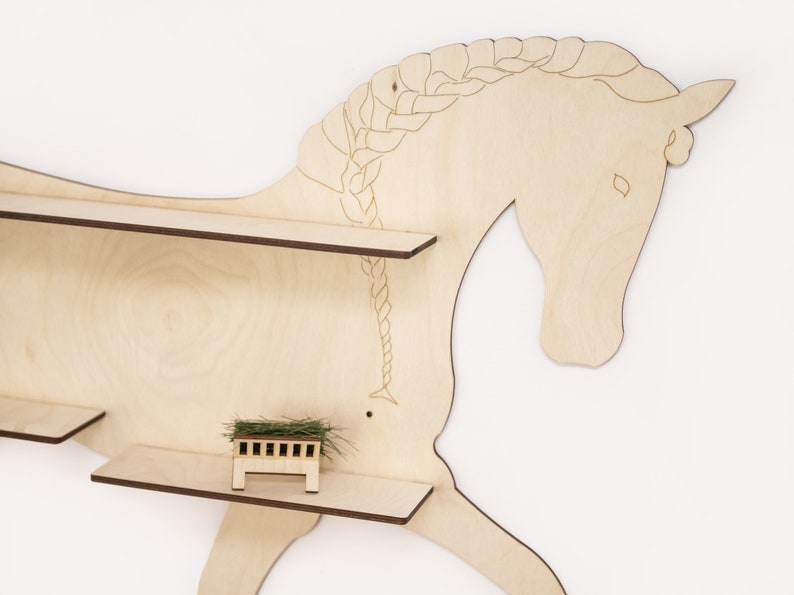 May include: Wooden horse-shaped shelf with two shelves. The horse has a braided mane and tail. The shelves are made of light wood and have a brown edge.