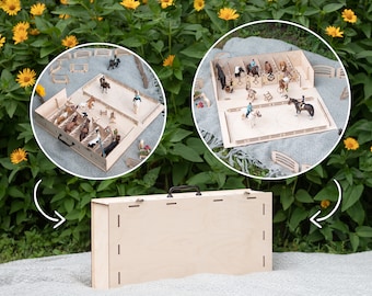 May include: A wooden toy horse stable with a removable top and a separate play area. The stable has stalls for horses and a fenced-in area for riding. The stable is closed and the play area is open.