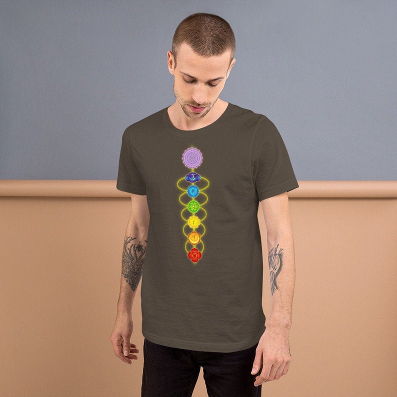 May include: A brown t-shirt with a graphic of the seven chakras, a spiritual concept in Hinduism and Buddhism, represented by colorful circles and a yellow line connecting them.