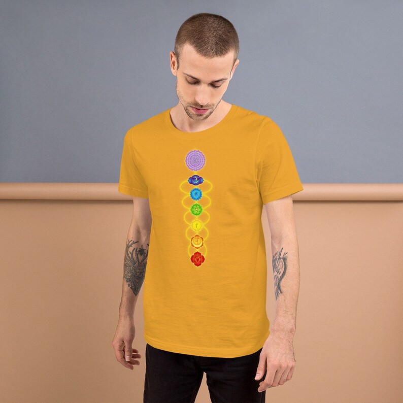 May include: A yellow t-shirt with a graphic of the seven chakras, a spiritual concept in Hinduism and Buddhism, represented by colored circles and symbols.