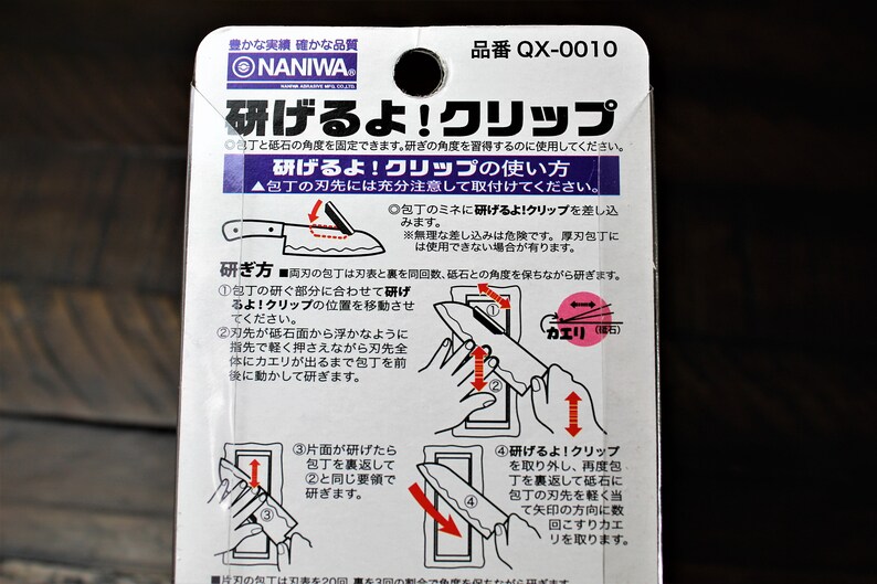 May include: A white and pink instruction card for a knife sharpening tool. The card shows a diagram of how to use the tool to sharpen a knife. The text on the card reads "研げるよ!クリップ" which translates to "Sharpen it! Clip".
