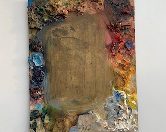 May include: A wooden artist's palette with a large, central, brown area surrounded by a border of colorful, dried paint. The palette is marked with the dimensions "24x36".