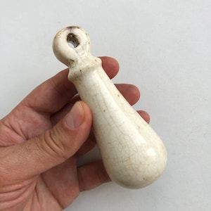 May include: White ceramic door pull with a loop handle. The handle has a crackled glaze finish.