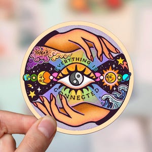 May include: A colorful sticker with a stylized eye and the text "EVERYTHING IS CONNECTED". The eye is surrounded by a rainbow-colored background with celestial imagery, including stars, planets, and a yin-yang symbol.