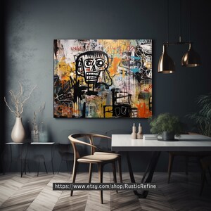 Peut inclure: Peinture abstraite avec une figure de cr&acirc;ne noir et blanc au centre. La peinture est sur toile et a un fond color&eacute; avec des lignes noires et du texte de style graffiti. La peinture est accroch&eacute;e &agrave; un mur gris fonc&eacute; dans un d&eacute;cor de salle &agrave; manger moderne.