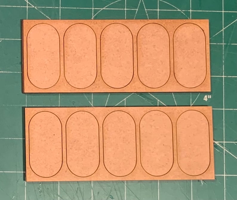 May include: Two wooden boards with six oval-shaped cutouts each. The boards are 4 inches wide and are made of light brown wood.