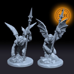 Puede incluir: Dos figuras en miniatura grises y detalladas de criaturas parecidas a monos alados que sostienen lanzas. Las figuras están en posición de pie y en cuclillas.