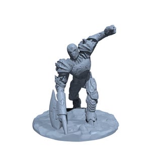 May include: A gray miniature figurine of a warrior in armor, holding an axe and raising a fist. The figurine is on a textured base, with detailed armor and a helmet. The overall theme is fantasy and tabletop gaming.