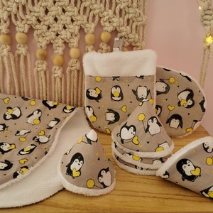 Könnte beinhalten: Sechsteiliges Set an grauen und weißen Küchenhandtüchern mit Pinguin-Motiv. Die Handtücher sind aus Baumwolle und haben eine weiche, saugfähige Textur. Das Set enthält ein großes rundes Handtuch, ein kleineres rundes Handtuch und vier konische Handtücher. Die Handtücher sind mit einem Muster aus Pinguinen verziert, die Herzen und Ballons halten.