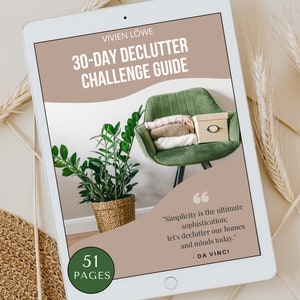 Könnte beinhalten: Ein Tablet-Computer zeigt einen Entrümpelungsratgeber. Auf dem Bildschirm steht "30-DAY DECLUTTER CHALLENGE GUIDE" und "51 PAGES". Ein Zitat von Da Vinci ist ebenfalls zu sehen. Der Hintergrund zeigt einen grünen Stuhl, eine Pflanze und eine Box.