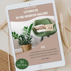 Può includere: Un tablet digitale mostra una guida al decluttering intitolata "Sfida di decluttering di 30 giorni" di Vivien Lowe. L'immagine presenta una sedia verde con vestiti piegati e una scatola, una pianta in vaso e una citazione di Da Vinci.