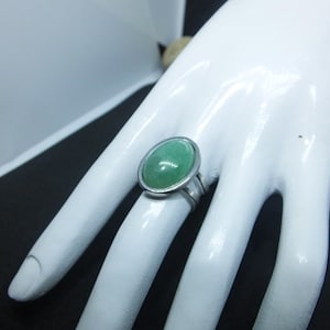 Puede incluir: Un anillo de plata con una piedra ovalada verde.