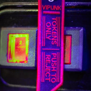 May include: A pink and black keychain with the text "VIPLINK" and "TOKENS ONLY PUSH TO REJECT" in white.