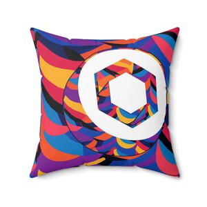 May include: A colorful throw pillow with a white circle and a hexagon inside. The pillow has a geometric pattern with shades of red, orange, yellow, blue, purple, and black.