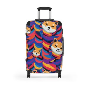 May include: A black rolling suitcase with a colorful pattern of Shiba Inu dog faces and abstract shapes in shades of blue, red, yellow, and purple.