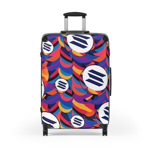 May include: A black suitcase with a colorful abstract pattern featuring a repeating logo. The logo is a white circle with a blue three-sided shape inside.