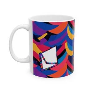 May include: White ceramic mug with a colorful abstract design featuring geometric shapes in shades of blue, purple, red, yellow, and black.