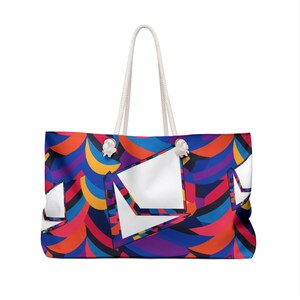 May include: Large tote bag with a vibrant, abstract pattern in shades of blue, red, orange, and purple. The bag features white geometric shapes and a white rope handle. A stylish and colorful accessory for carrying essentials.