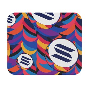 May include: A colorful mouse pad with a repeating pattern of abstract shapes and a white circle with a blue three-line logo in the center.