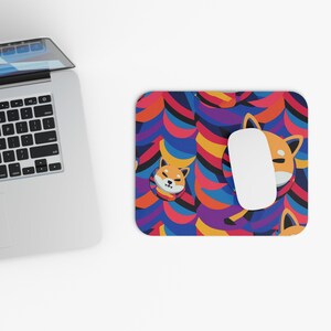 May include: A colorful mouse pad with a repeating pattern of orange cartoon dogs wearing blue and purple scarves. The background is a mix of blue, red, yellow, and purple stripes.