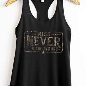 May include: Black racerback tank top with a camouflage design that reads "MISS NEVER - DO NO WRONG." The tank top is hanging on a gold-colored hanger. The Bella Cowgirl Boutique logo is on the bottom left.