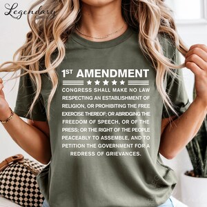 A woman wearing a green t-shirt with text printed on it.