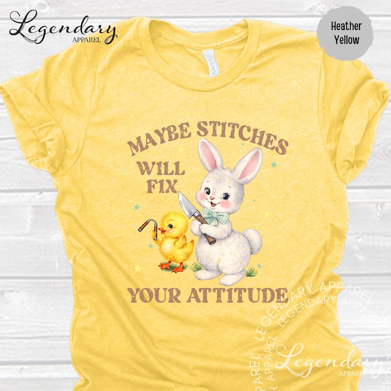 The image is a yellow t-shirt with a cartoon rabbit and a yellow duck holding a knife, accompanied by the text "MAYBE STITCHS WILL FIT YOUR ATTITUDE".