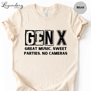 a beige t-shirt with a bold, graphic design that reads "GENX" in large letters. Below the text, it says "GREAT MUSIC. SWEET PARTIES. NO CAMERAS".
