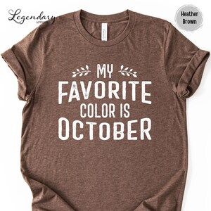 A brown t-shirt with the text "MY FAVORITE COLOR IS OCTOBER" printed on it.